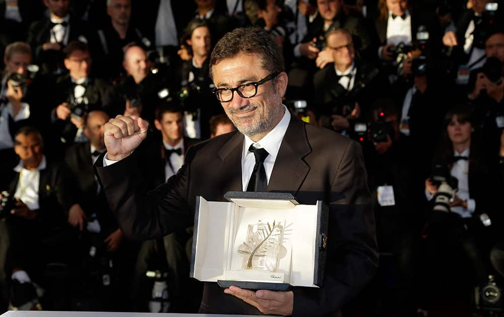 Director Nuri Bilge Ceylan poses with the Palme d'Or award for the film Winter Sleep during a photo call following the awards ceremony at the 67th international film festival, Cannes.