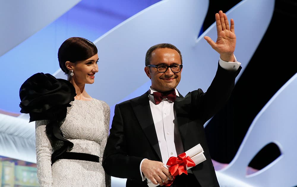 Director Andrey Zvyagintsev, right, acknowledges the audience after winning the Best Screenplay award for the film Leviathan, which was presented to him by actress Paz Vega during the awards ceremony for the 67th international film festival, Cannes.