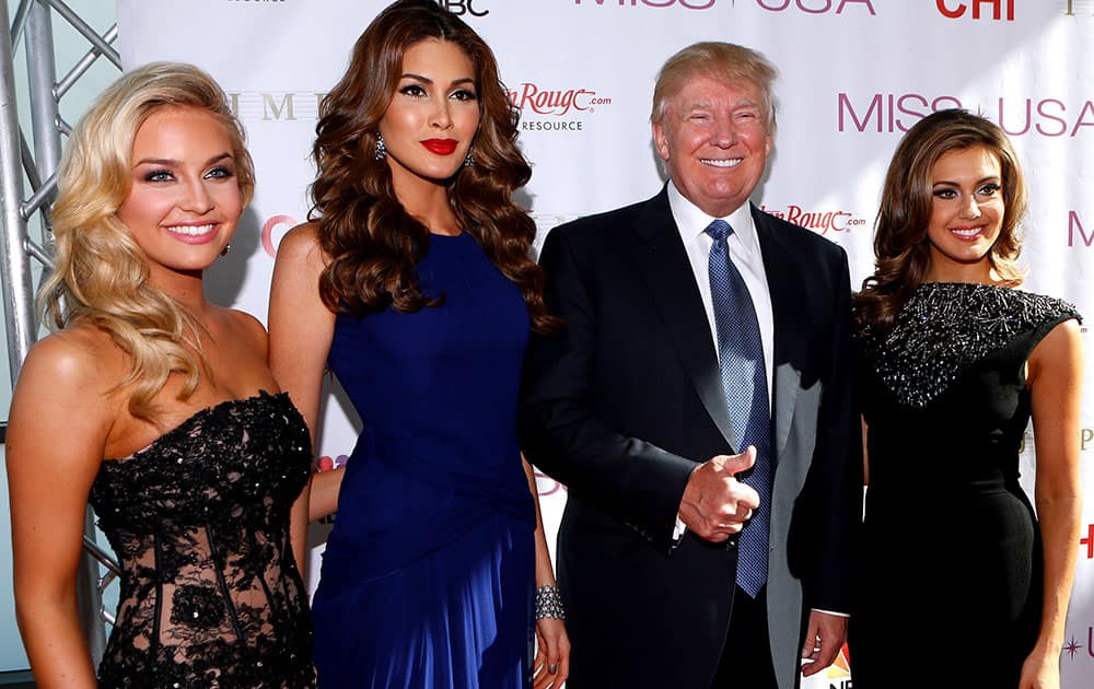 From left, Miss Teen USA 2013 Cassidy Wolf, Miss Universe 2013 Gabriela Isler, Donald Trump, and Miss USA 2013 Erin Brady pose during a red carpet event before the Miss USA 2014 pageant in Baton Rouge, La.