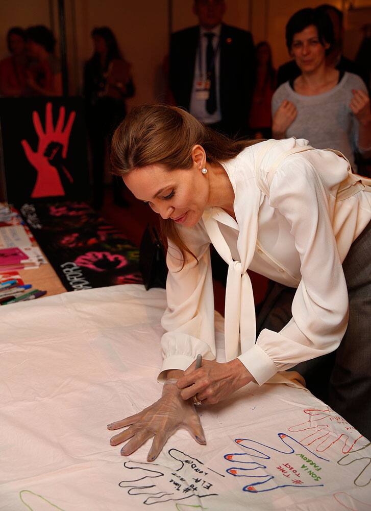 US actress Angelina Jolie, Special Envoy of the United Nations High Commissioner for Refugees, draws the outline of her hand to show support at the 'End Sexual Violence in Conflict' summit in London.