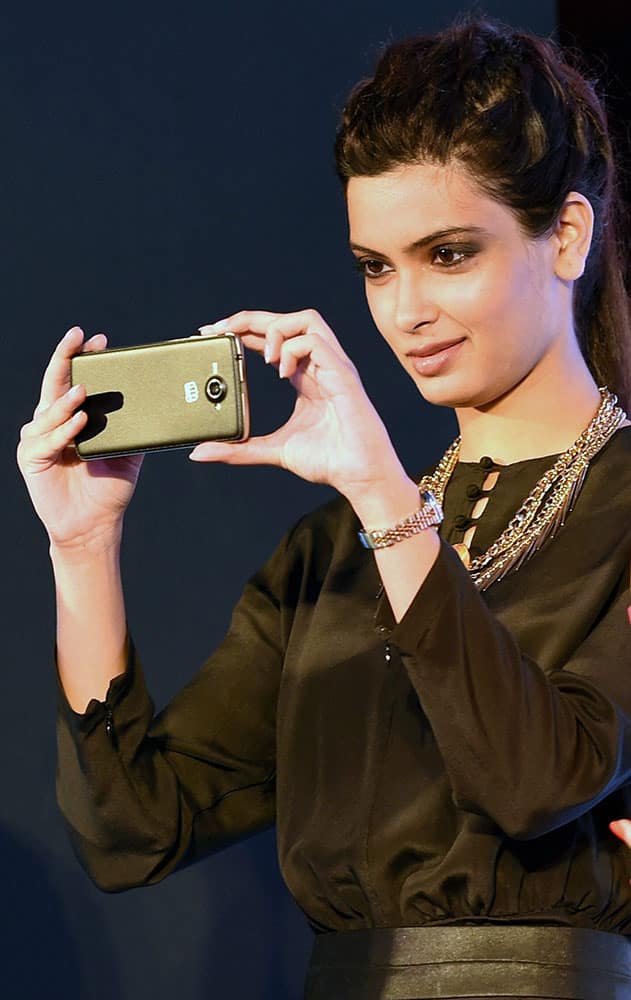 Diana Penty clicking pictures from the Micromax Canvas Win smartphone during its launch in New Delhi.