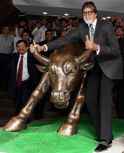 Bollywood actor Amitabh Bachchan poses with the bull statue at BSE during a promotional event of his TV show 'Yudh' in Mumbai.