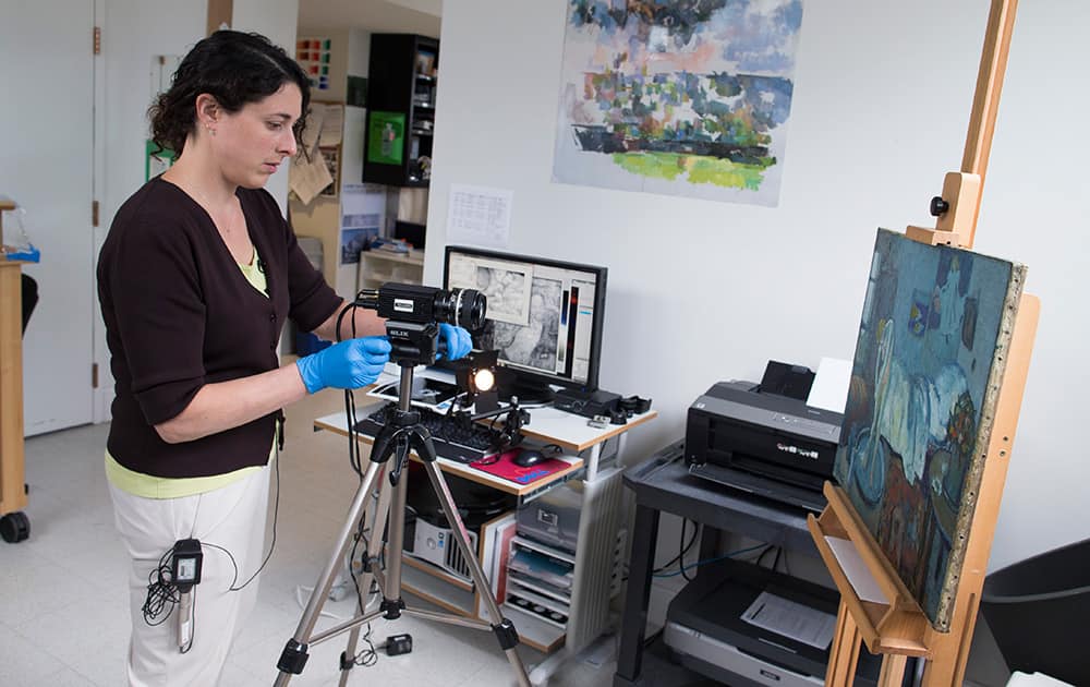 Patricia Favero, associate conservator at The Phillips Collection, sets up an infared camera to view an image of a man found underneath one of Picasso's first masterpieces, 'The Blue Room', in Washington. 