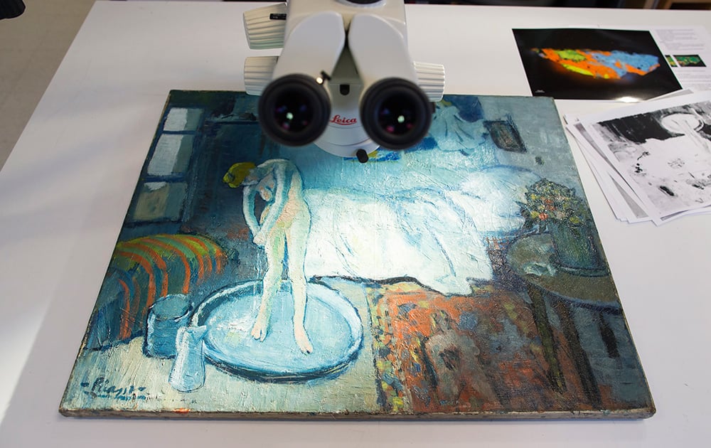 'The Blue Room,' one of Pablo Picasso's first masterpieces sits under a microscope at The Phillips Collection, in Washington. Scientists and art experts have found a hidden painting beneath the painting.