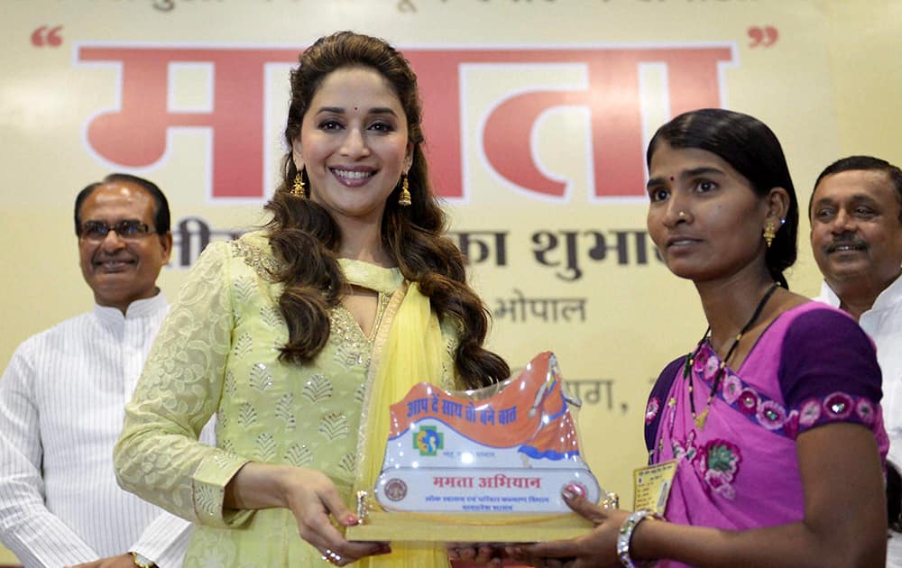 Madhuri Dixit felicitates an 'Asha' worker as Madhya Pradesh Chief Minister Shivraj Singh Chouhan looks on during the launch of 'Mamta Abhiyan' in Bhopal. Mamta Abhiyaan aims to decrease maternal and infant mortality rates. 