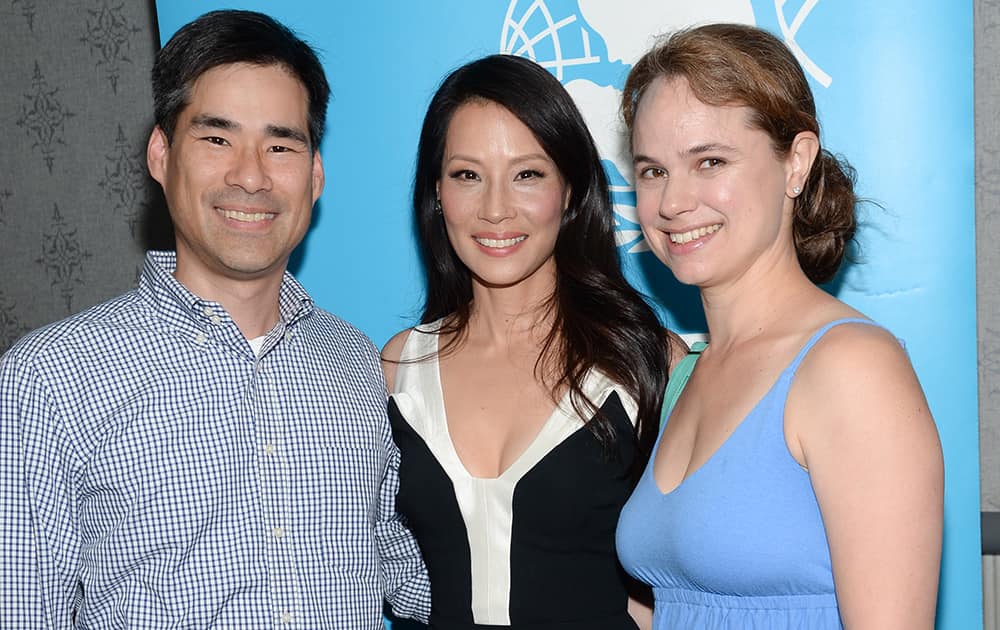 Director and UNICEF Ambassador Lucy Liu, center, poses with her brother John Liu and his wife Stephanie at the premiere of 'Meena,' a short film on sex trafficking, at the AMC Loews Theater, in New York.