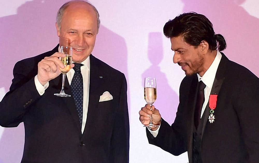 Bollywood superstar Shah Rukh Khan raises his glass after being conferred with the Chevalier de la Legion d'Honneur, the highest honour in France by Minister for Foreign Affairs and International Development of France Laurent Fabius, in Mumbai.