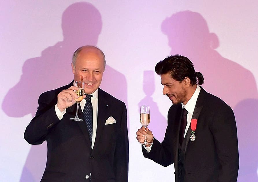 Bollywood superstar Shah Rukh Khan raises his glass after being conferred with the Chevalier de la Legion d'Honneur, the highest honour in France by Minister   for Foreign Affairs and International Development of France Laurent Fabius, in Mumbai.