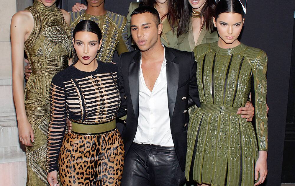 Fashion designer Olivier Rousteing, center, Kim Kardashian, left, and her sister Kendall Jenner pose prior to attend the Vogue party, in Paris.