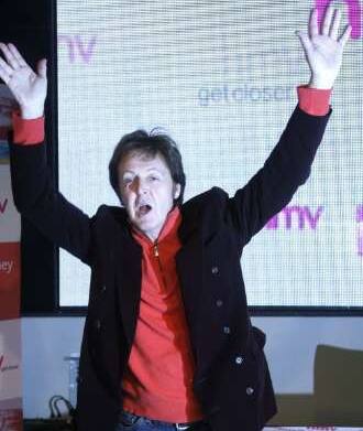 Paul McCartney waves for fans at a signing session at a music store, in UK. 