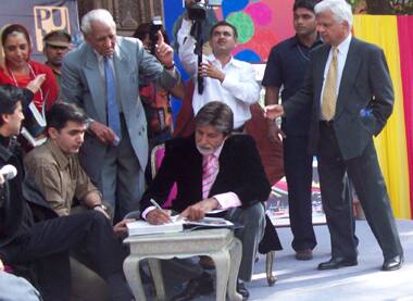 Amitabh Bachchan signs a book at the Jaipur literary festival.