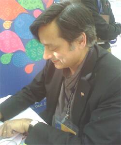 Writer Shashi Tharoor signs autograph for eager fans.