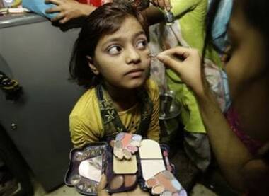 A relative applies makeup to the face of Rubina Ali Qureshi before her departure for Oscars ceremony.