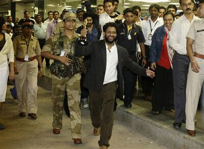 Oscar award winner Resul Pookutty, center holding statuette, arrives at the international airport in Mumbai.