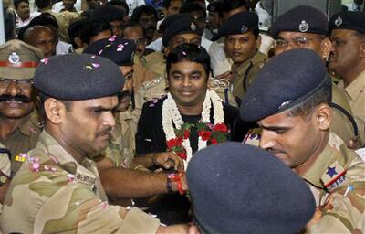 Indian music composer A.R. Rahman is escorted out by policemen as he arrives back home after receiving two Oscars, for best original soundtrack and best original song, both from the movie 