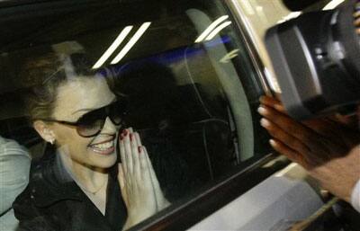 Australian singer Kylie Minogue gestures towards a fan after arriving at the international airport in Mumbai, India.