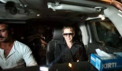 Australian singer Kylie Minogue sits in a car after arriving at the international airport in Mumbai early February 26, 2009. Minogue is in Mumbai to work on a music video for the Bollywood film 'Blue'