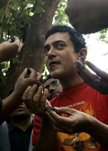 Fans surround the birthday boy to feed him a piece of his birthday cake.