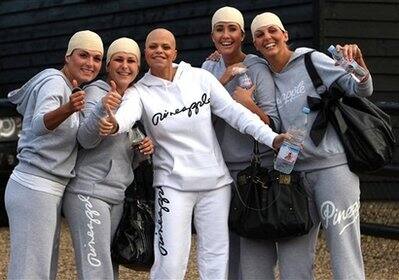 Reality television star Jade Goody, center, who had a tube extending from inside her left sleeve and apparently feeding from a pocket, poses with friends wearing joke skull caps outside her Upshire, s