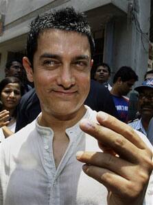 Bollywood actor Aamir Khan shows the indelible ink mark on his finger after casting his vote at a polling station in Mumbai, India.