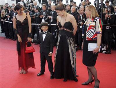 Indian child actor from the movie 'Slumdog Millionaire' Ayush Manesh Khedekarl, second left, arrives with unidentified guests for the screening of the film 'Looking for Eric' at the 62nd International