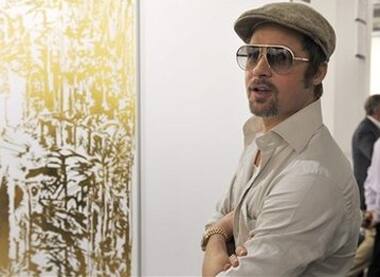 Brad Pitt looks at the art work 'end of knowledge' during his visit to an international art show.