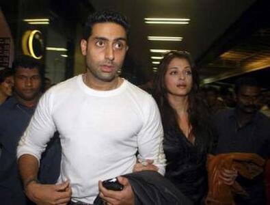 Abhishek with wife Aishwarya at the Mumbai International Airport as they depart to Macau for the IIFA Awards .