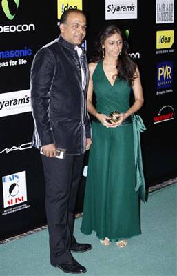 Bollywood director Ashutosh Gowariker and his wife Sunita pose for photographers at the 10th International Indian Film Awards presentation at a casino-hotel complex in Macau