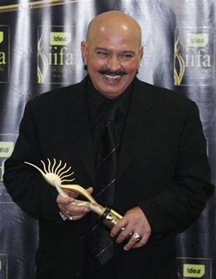 Indian director Rakesh Roshan celebrates with the trophy after winning the Director of the Decade award at the 10th International Indian Film Awards presentation