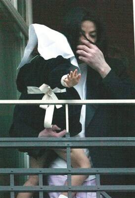 In this Nov. 21, 2002 file photo, U.S. pop singer Michael Jackson holds his daughter Paris Katherine as he stands in the window of his suite in the Adlon hotel in Berlin.