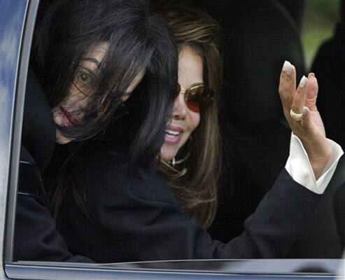 In this March 4, 2005 file photo, entertainer Michael Jackson, left, peers over his sister LaToya's shoulder from the rear seat of his car after leaving court for his child molestation trial at the Sa