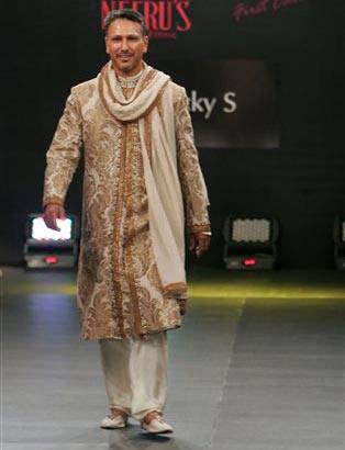 Indian golfer Jeev Milkha Singh presents a creation by Rocky S at the Bangalore Fashion Week 2009.