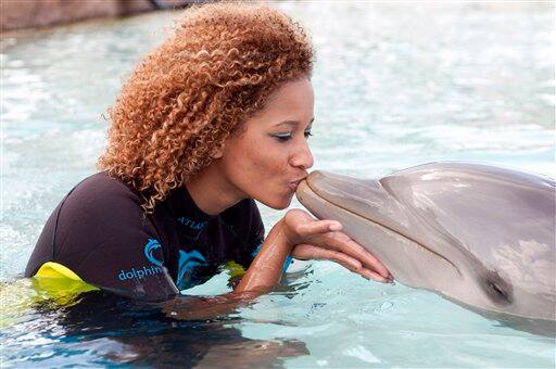 In this photo provided by the Miss Universe Organization, Andella Chileshe-Matthews, Miss Zambia 2009, kisses a dolphin at Dolphin Cay in Atlantis, Paradise Island, Bahamas.