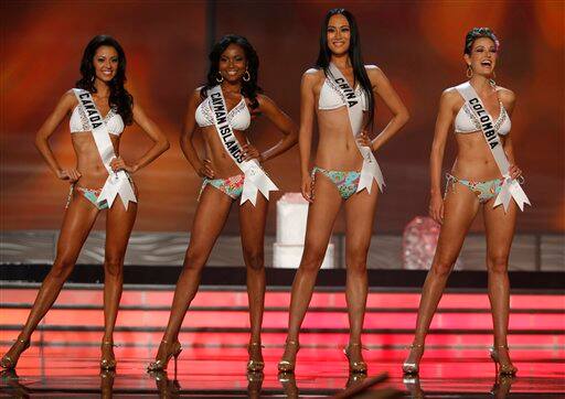 Miss Colombia Michelle Rouillard, right, laughs as she stands with, right to left, Miss China Jingyao Wang, Miss Cayman Islands Nicosia Lawson, and Miss Canada Mariana Valente during the swimsuit even