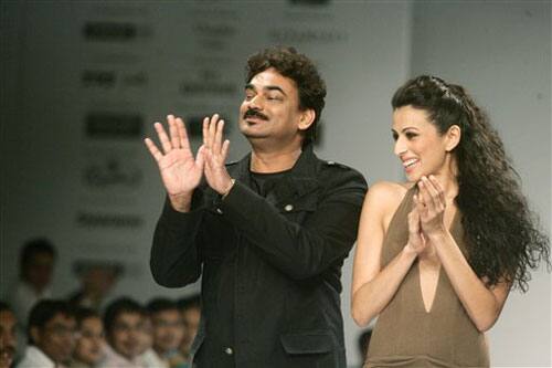 Indian designer Wendell Rodckricks, left and a model gesture during Kolkata Fashion Week in Calcutta, India, 