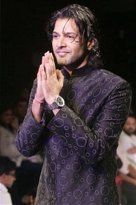 Indian classical Sarod, musician Ayaan Ali Bangash, gestures as he displays an outfit designed by Zubair Kirmani