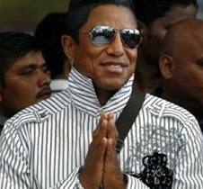 Jermaine Jackson gestures upon his arrival at the Chhatrapati Shivaji International Airport in Mumbai.