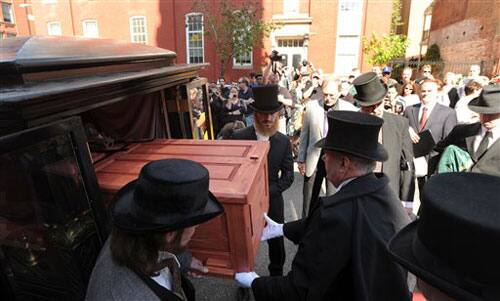 Pall bearers remove a casket from an antique hearse outside Westminster Hall in Baltimore during a reenactment of author Edgar Allan Poe's funeral