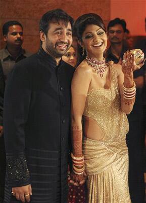 Bollywood actress Shilpa Shetty, right, and her husband Raj Kundra pose for the media as they arrive to host their wedding reception in Mumbai.