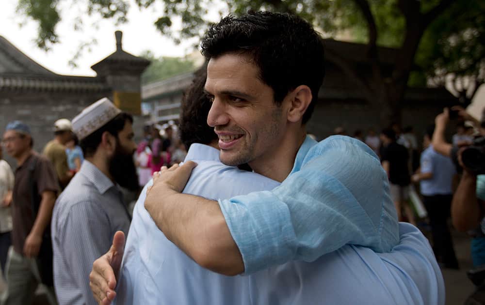 Muslim men great each others after attending an Eid al-Fitr morning prayer session at the Niujie mosque, the oldest and largest mosque in Beijing.