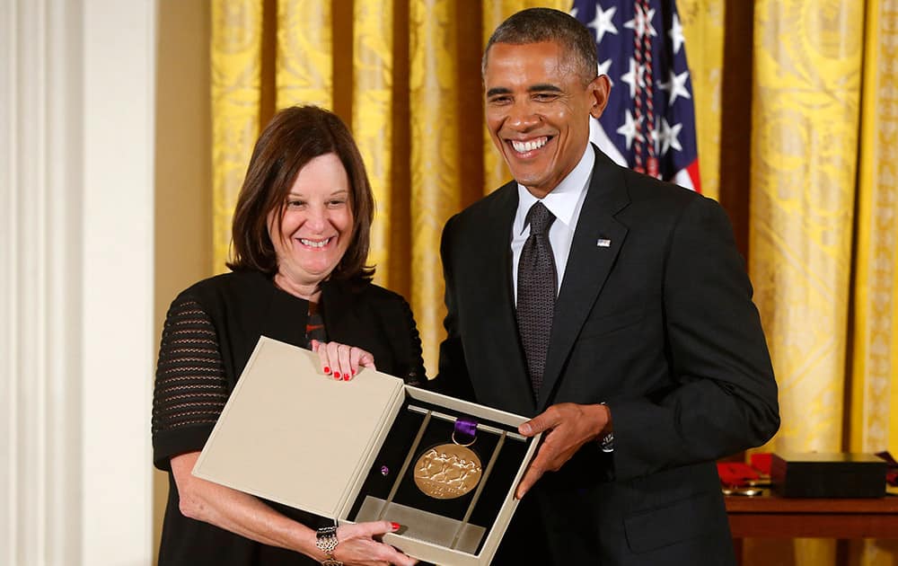 President Barack Obama awards the 2013 National Medal of Arts to the Brooklyn Academy of Music (BAM), and it is received by Karen Brooks Hopkins, during a ceremony in the East Room at the White House in Washington.