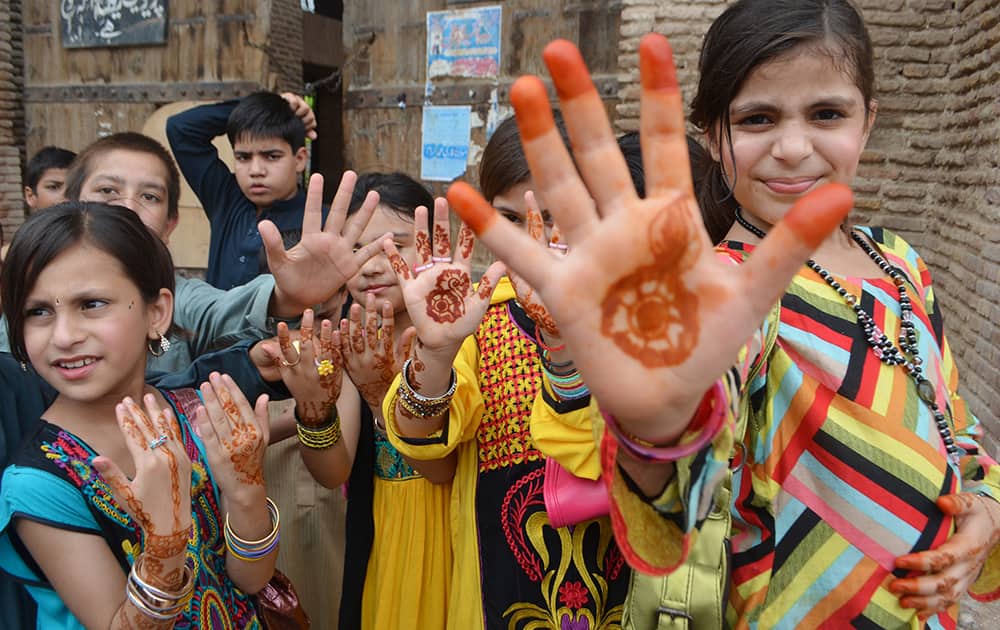 Pakistani girls show their hands painted with henna ahead of the Muslims Eid al-Fitr holiday that marks the end of the fasting month of Ramadan in Peshawar, Pakistan.