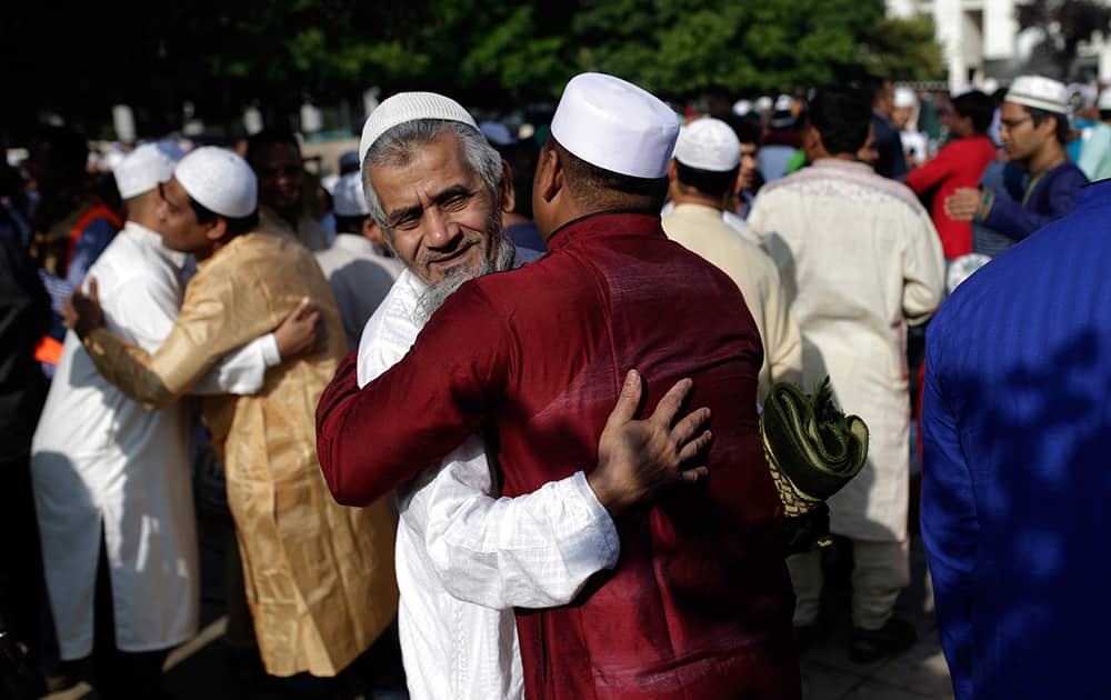 Muslim worshippers greet each others after the dawn prayer during the first day of the Eid al-Fitr, that marks the end of the holy fasting month of Ramadan, at Lisbon`s Martim Moniz square.