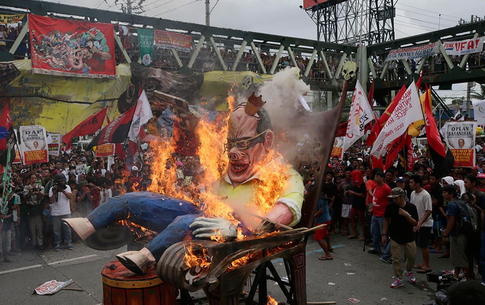 Protesters burn the effigy of Philippine President Benigno Aquino III during a rally to coincide with his State of the Nation Address at suburban Quezon city, northeast of Manila, Philippines.