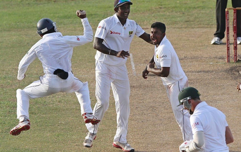 Sri Lankan bowler Rangana Herath celebrates with his teammates the dismissal of South African batsman Dale Steyn during the fifth day of the second test cricket match between South Africa and Sri Lanka in Colombo, Sri Lanka.