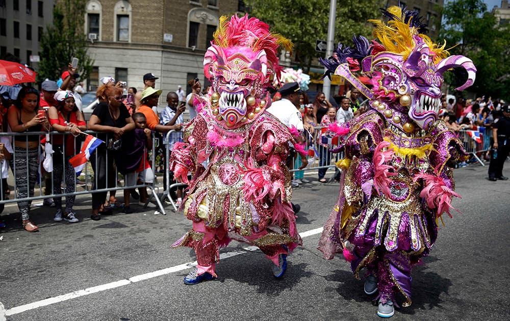 Men dressed in elaborate costumes march in the Dominican Day Parade in the Bronx borough of New York.