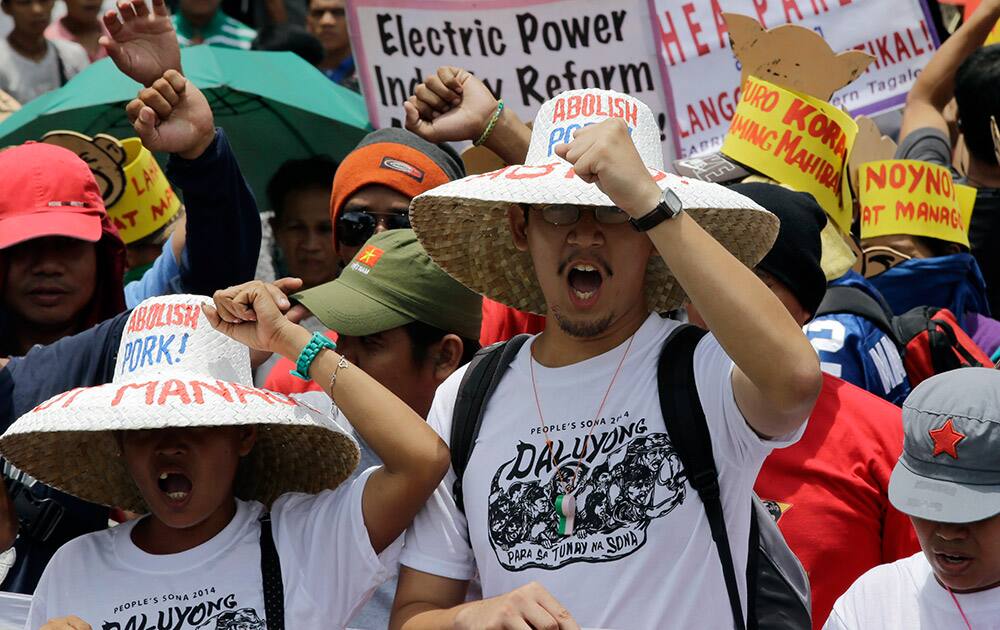 Protesters shout slogans as they march towards the residence of Philippine President Benigno Aquino III during a protest on the eve of Aquino`s State-of-the-Nation address at suburban Quezon city, northeast of Manila, Philippines.