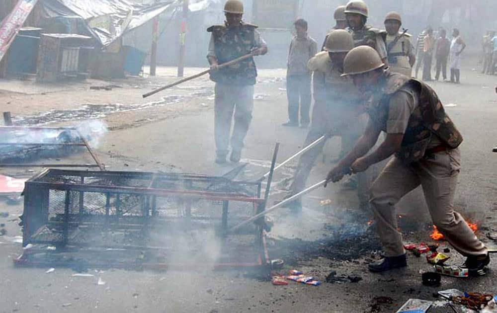 Police men dousing the fire at a rack during violent clashes between two communities over a land dispute in Saharanpur.