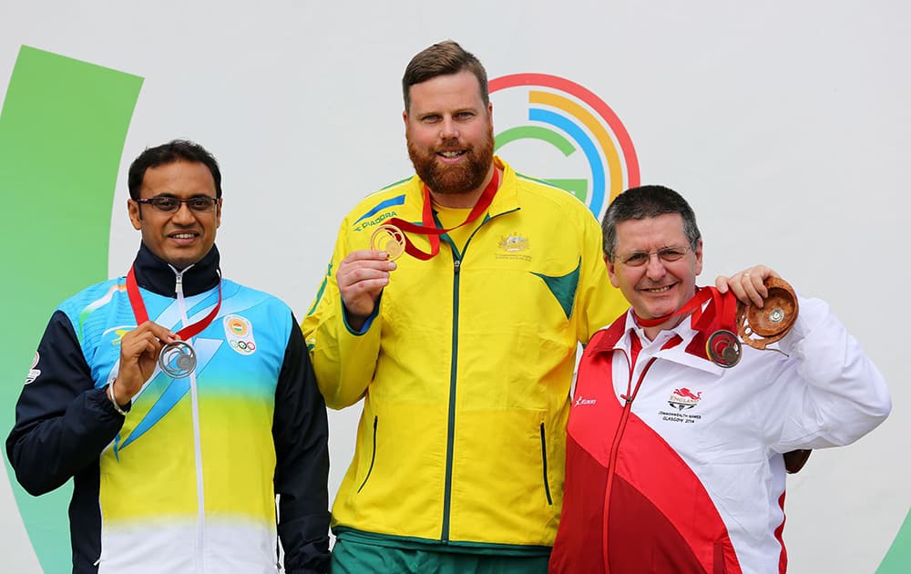 Australia`s Daniel Repacholi, centre, holds his gold medal with silver medalist India`s Prakash Nanjappa, left, and bronze medalist England`s Michael Gault following the final of the 10m Air Pistol Men at the Barry Buddon Shooting Centre in Carnoustie, Scotland, during the Glasgow 2014 Commonwealth Games.