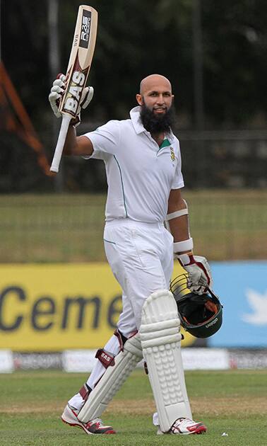 South African batsman Hashim Amla rasies his bat to celebrate scoring a century during the third day of the second test cricket match between South Africa and Sri Lanka in Colombo, Sri Lanka.